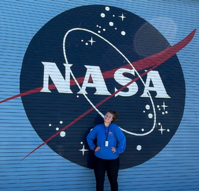 Savannah Toney standing in front of the NASA logo